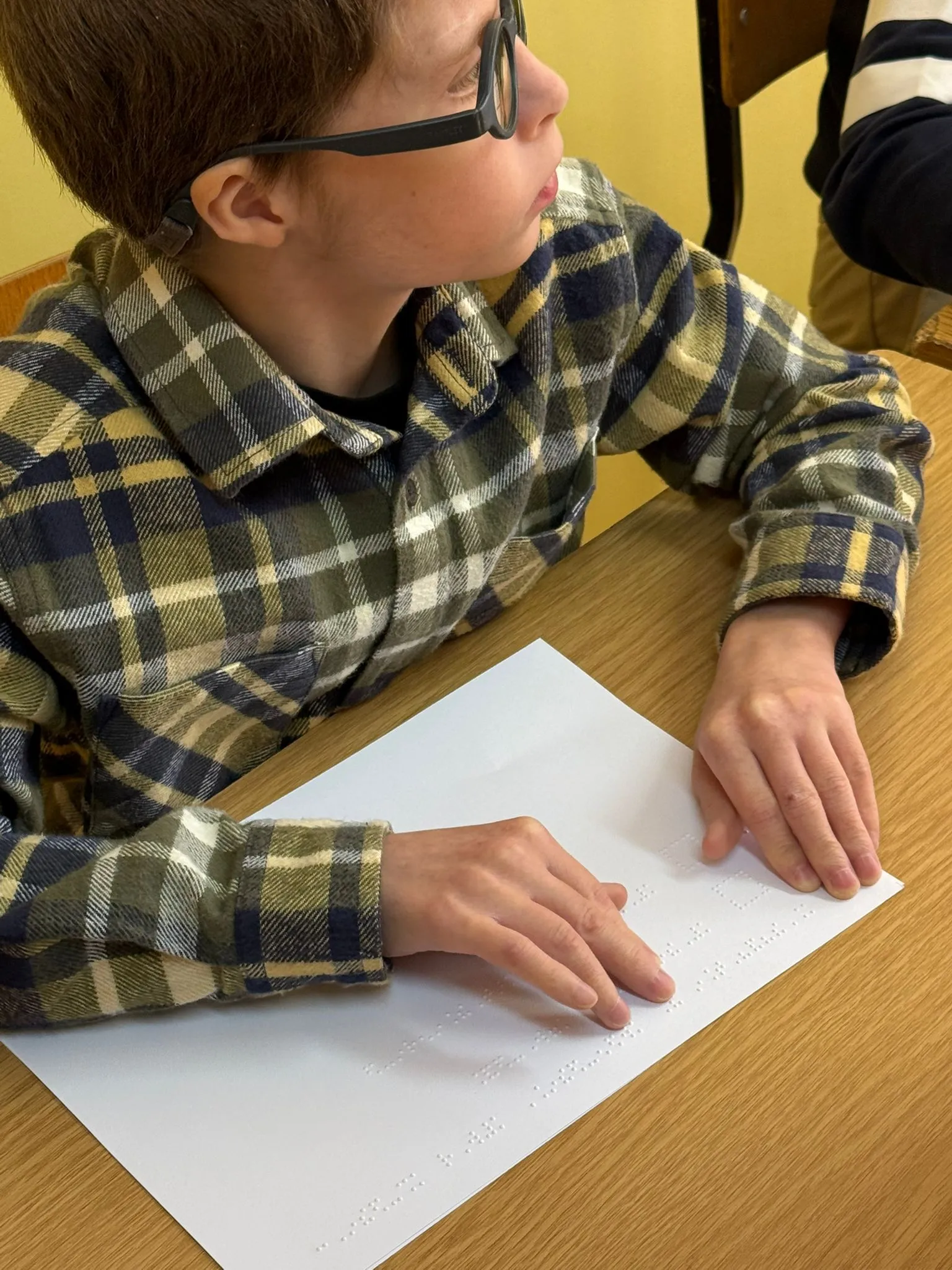 Uczeń korzysta z karty do głosowania w alfabecie Braille’a.