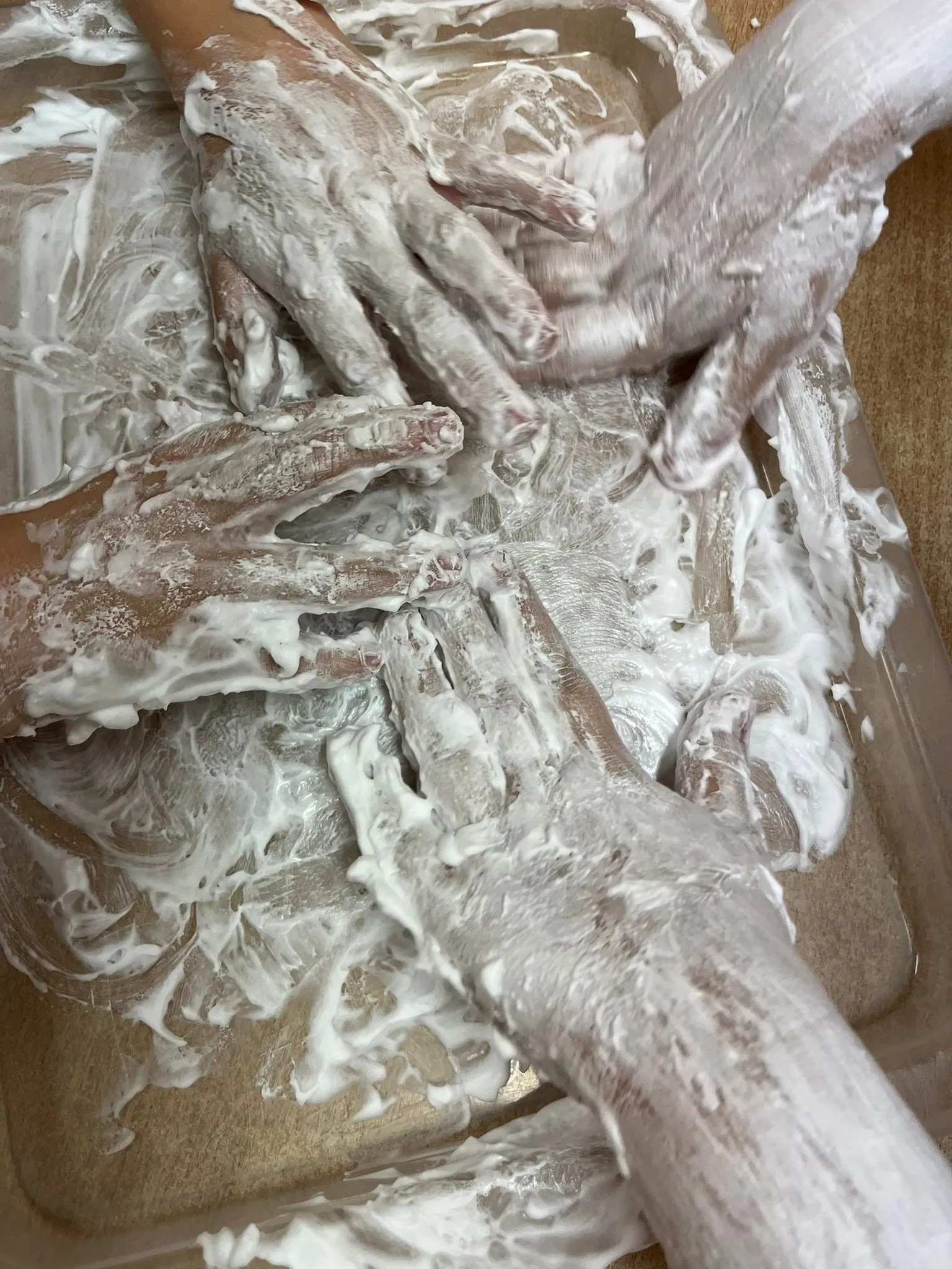 Dzieci bawią się masą sensoryczną z piany podczas zajęć arteterapii.